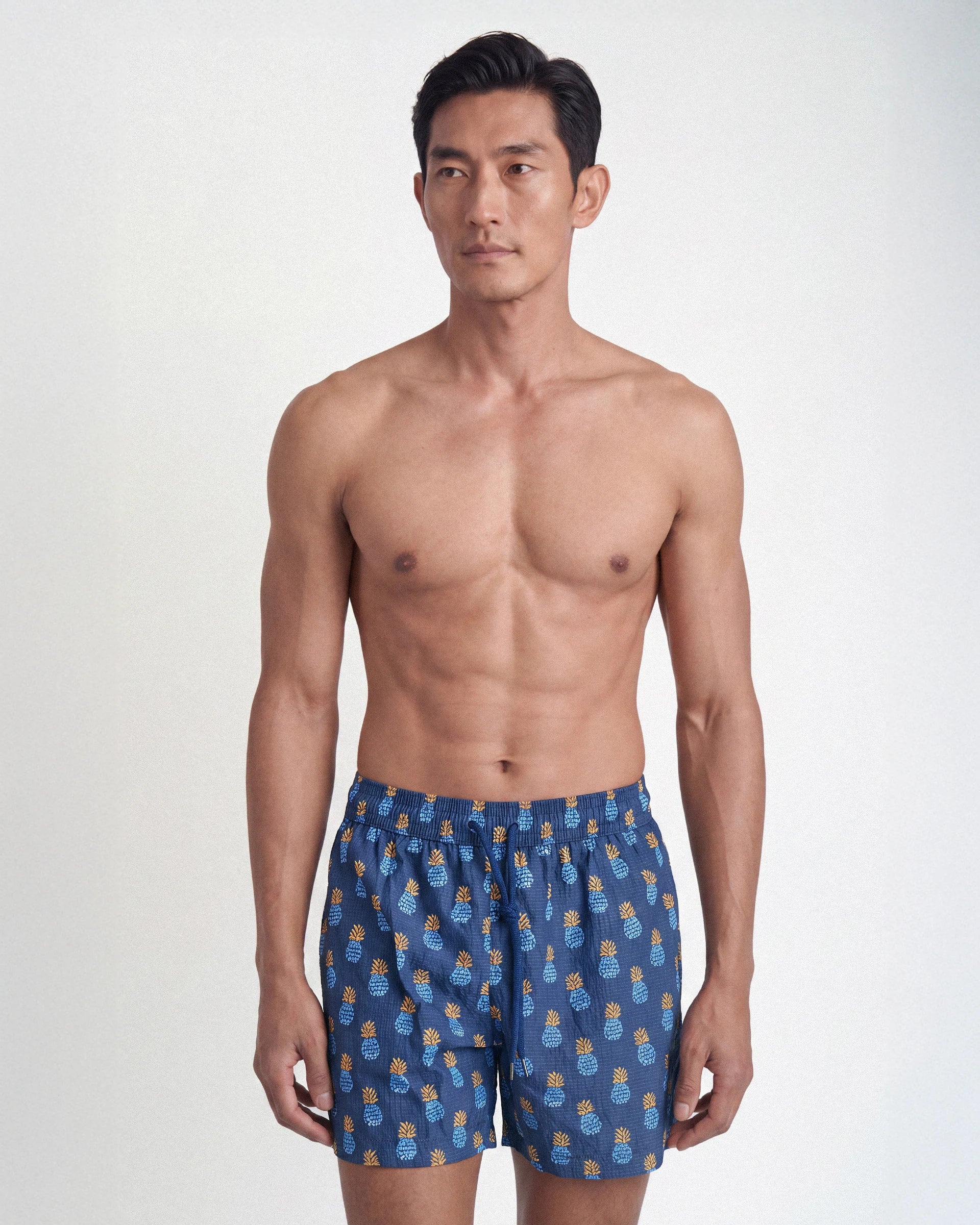 Patterned swim shorts with pineapple motifs
