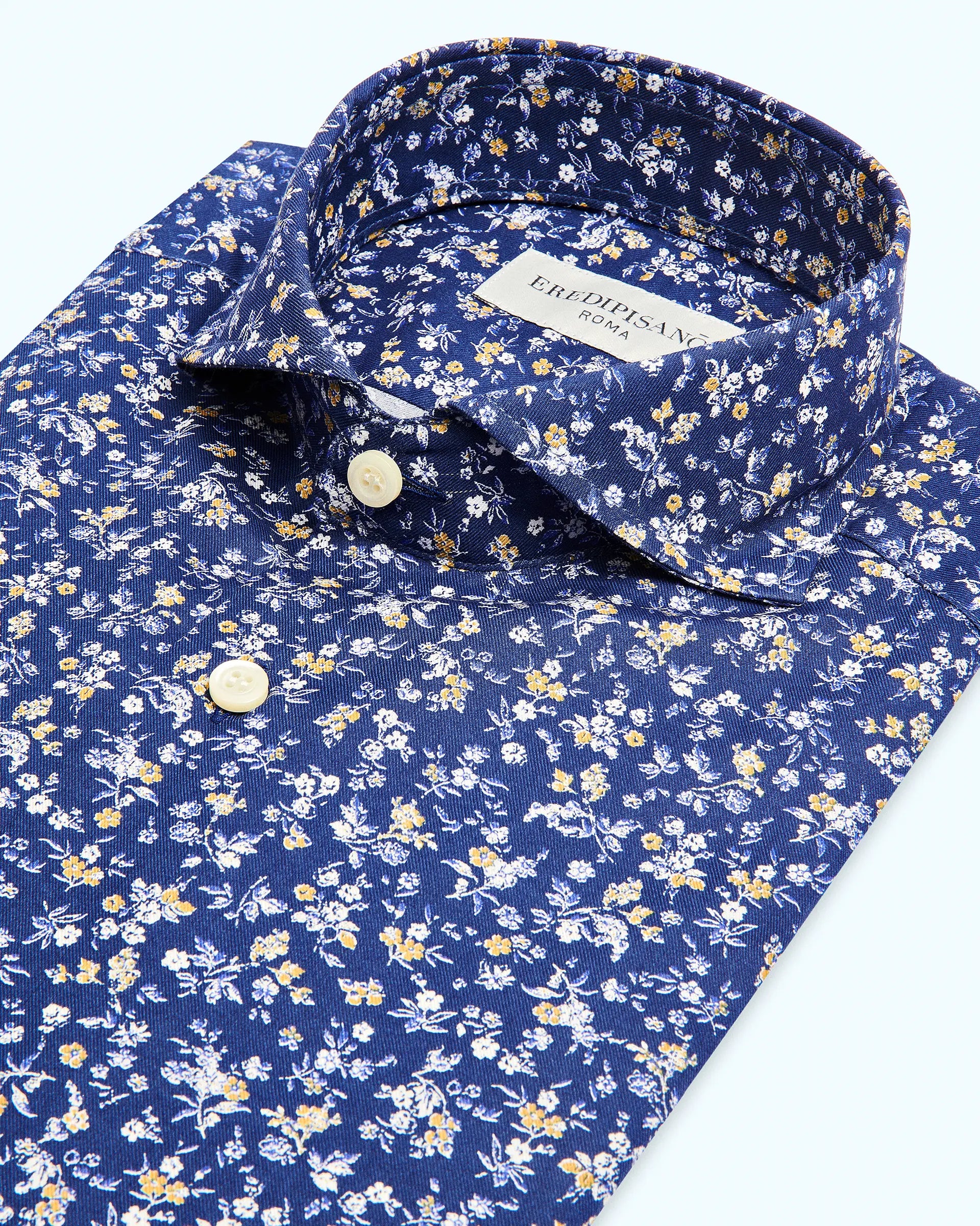 Camisa con estampado floral sobre fondo azul, corte moderno, cuello florentino